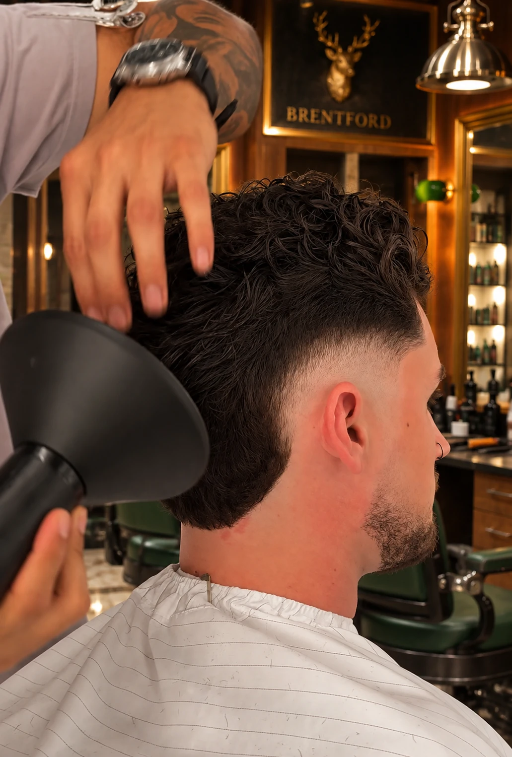 A Crew barber blow-drying a client's curls at Brentford