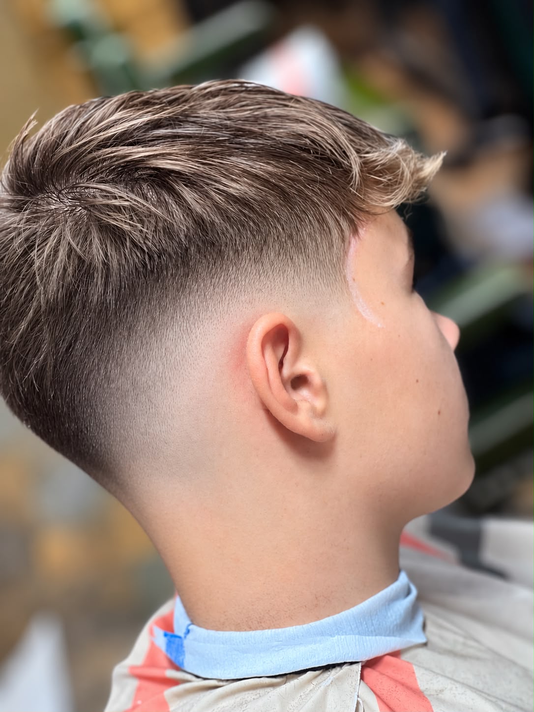 A boy's textured crop with a skin fade, cut at Crew Barbers