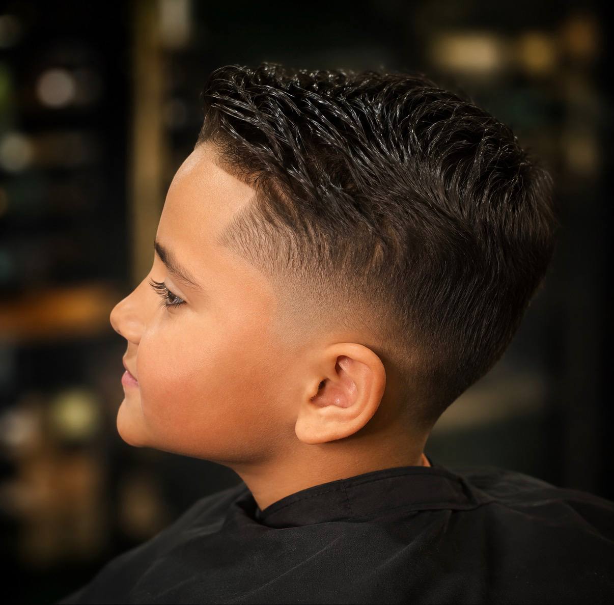 A boy's slicked pompadour with a fade, cut at Crew Barbers