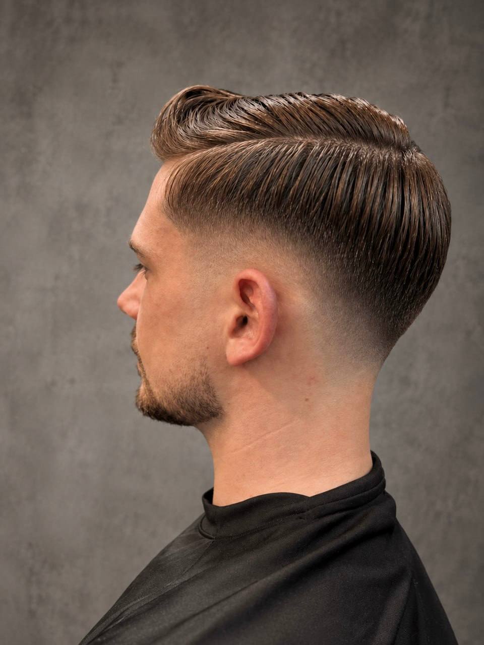 A swept-back pompadour, cut at Crew Barbers